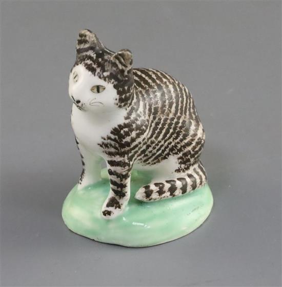 A rare Lowestoft porcelain figure of a seated tabby cat, c.1780, H. 6cm, ears restored